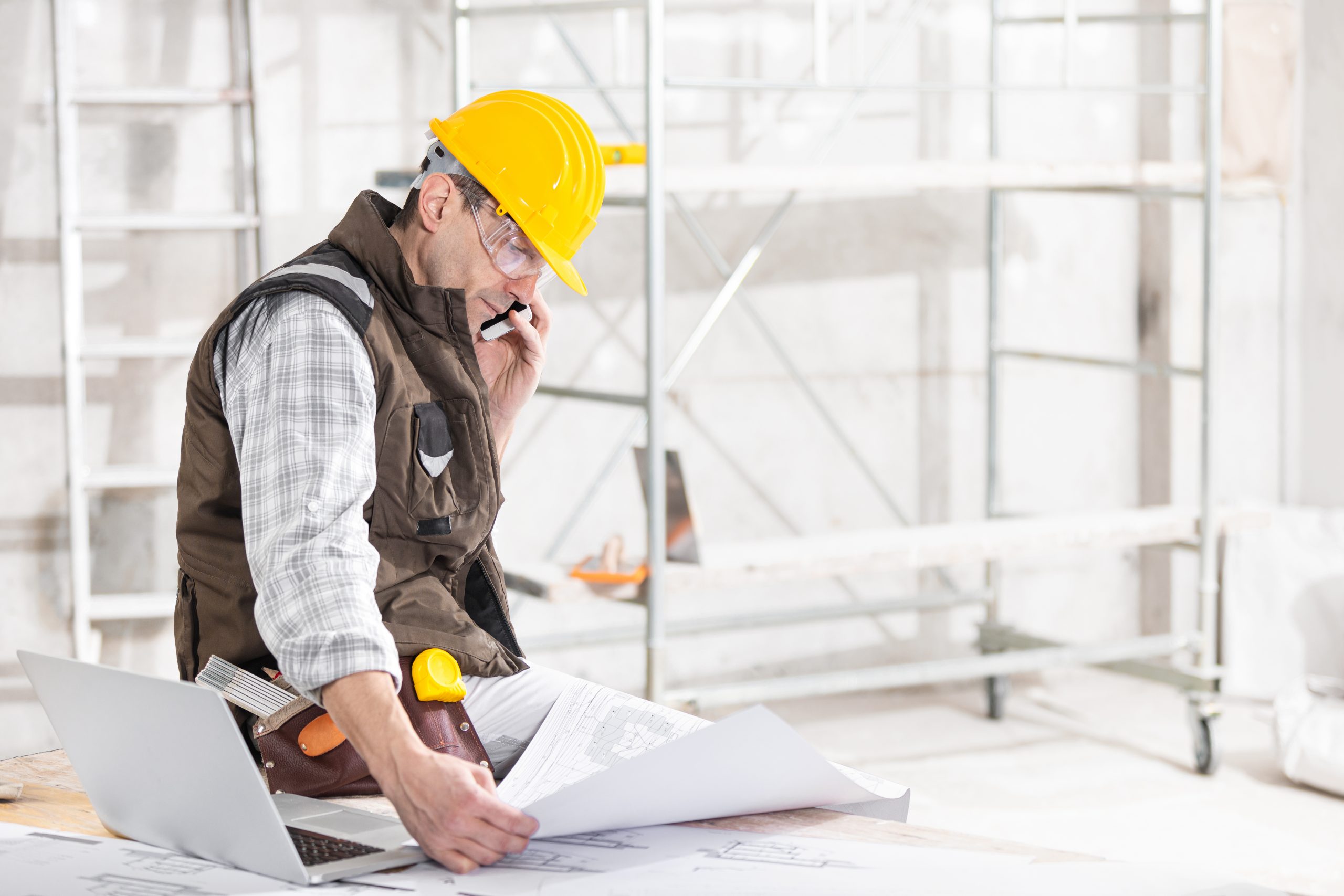 Building,Contractor,Talking,On,A,Mobile,Phone,As,He,Sits